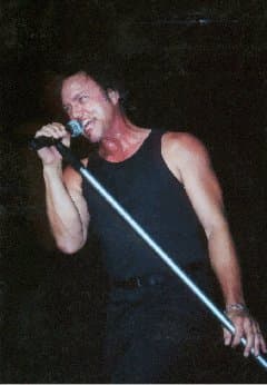 Geoff Tate singing with a mic and stand